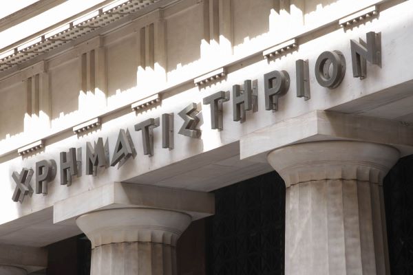 Lettering on a building with white columns. Example of signs using typefaces that harken back to inscriptions chiseled into stone in Ancient Greece.